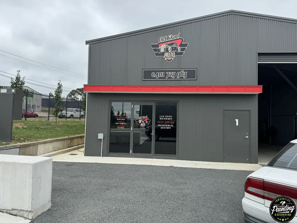 Freshly painted dark commercial building exterior with a red trim line