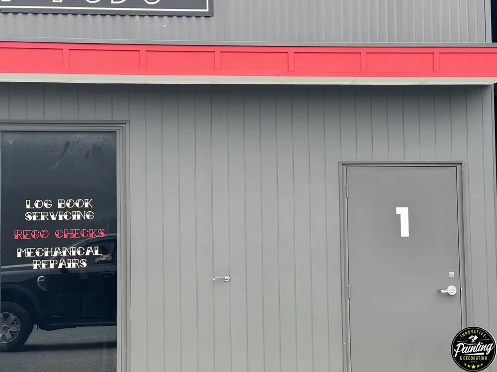 Freshly painted commercial cladding and entry door with crisp red trim