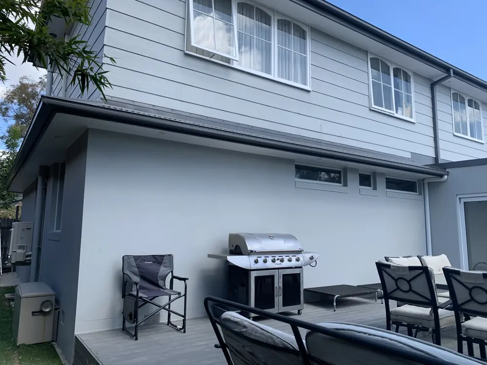Freshly painted two-storey home exterior with grey cladding and outdoor area