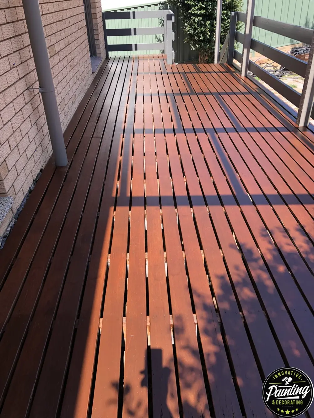 Narrow timber deck with a fresh rich-brown restored finish