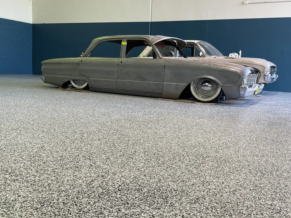 Classic car parked on a finished speckled epoxy floor inside a workshop