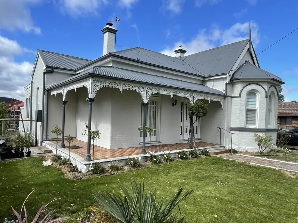 Freshly painted heritage-style home exterior with a grey roof and verandah