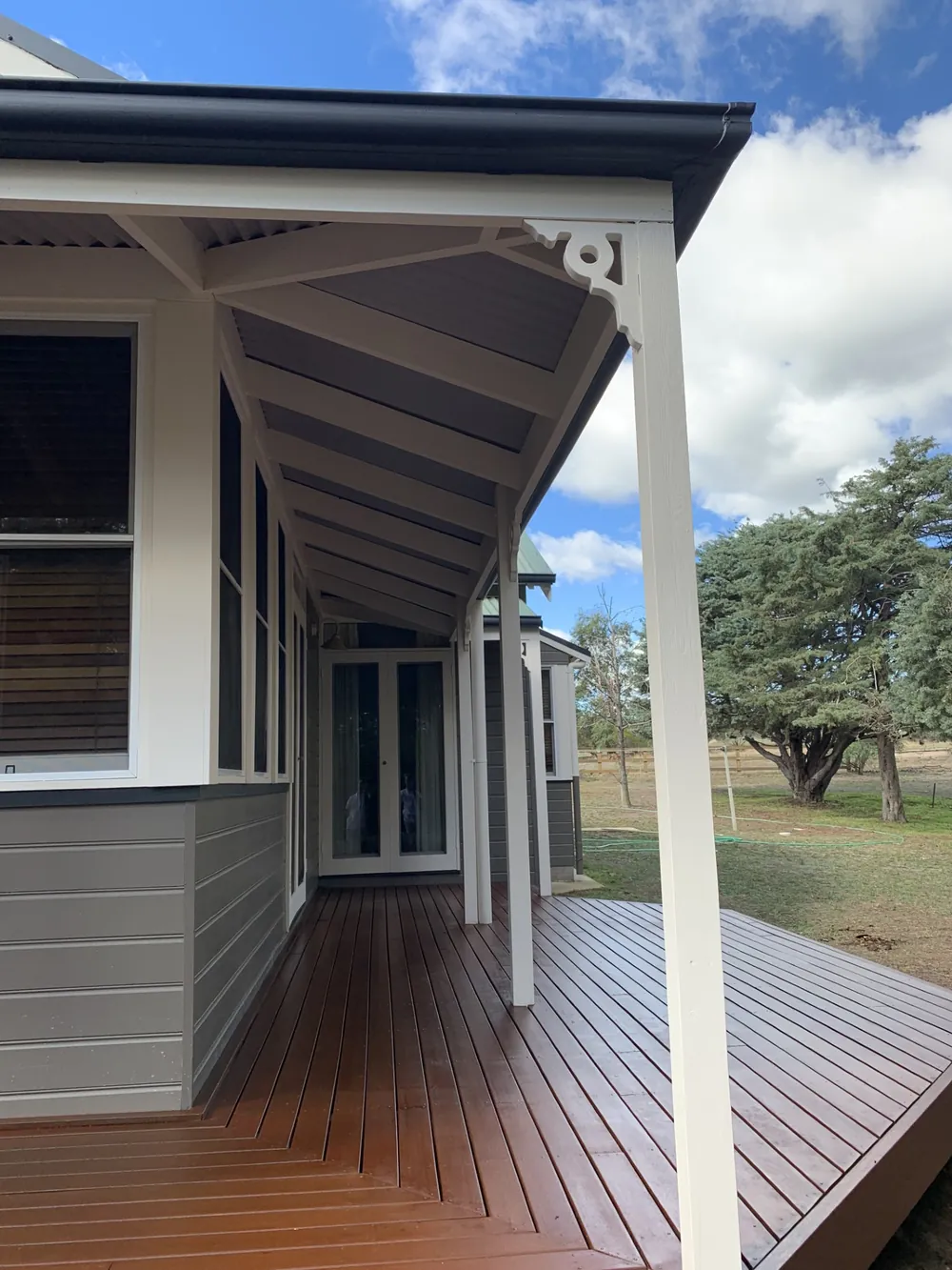 Restored timber verandah deck beside freshly painted grey cladding