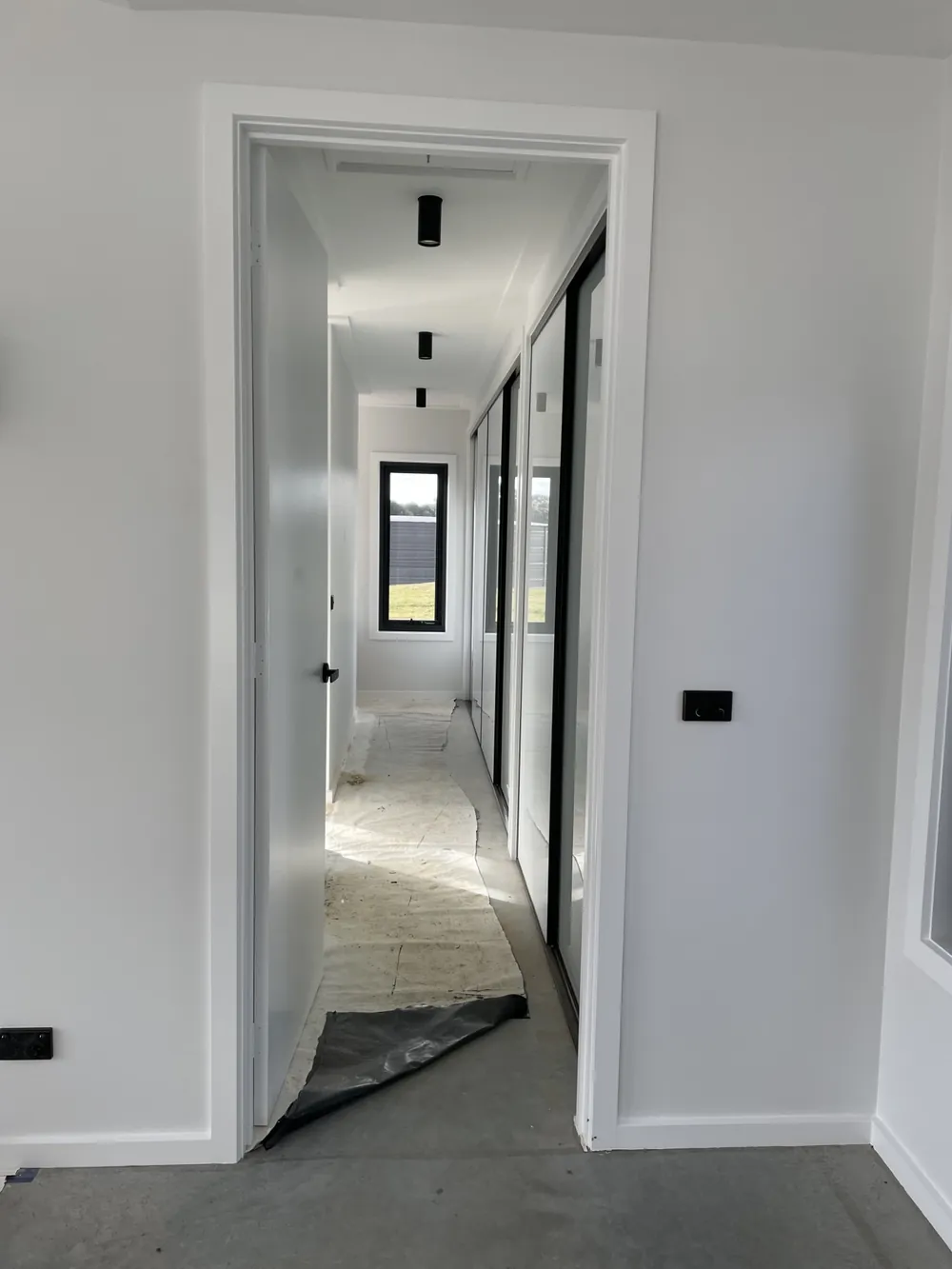 Freshly painted hallway with bright white walls and black door frames