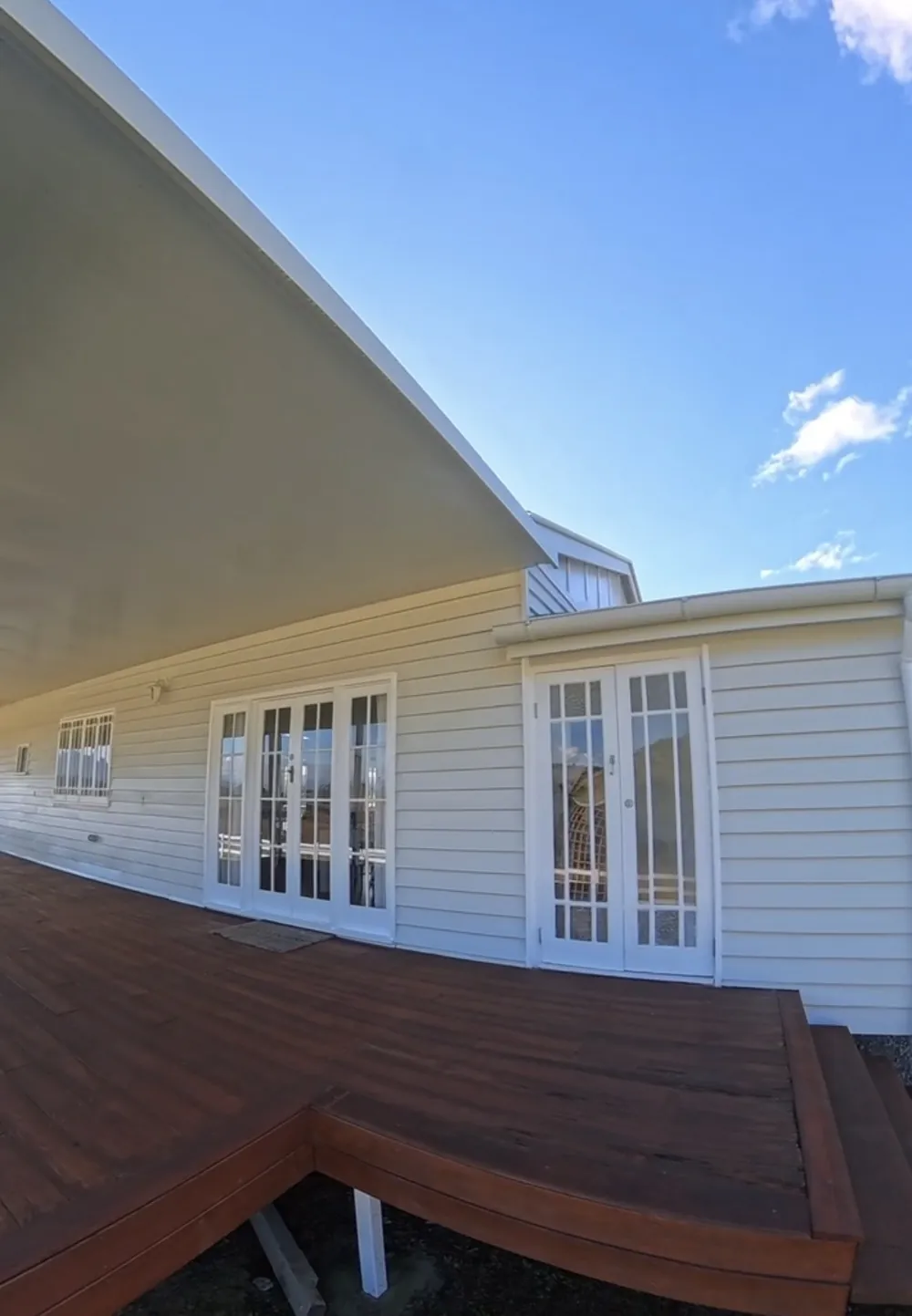 Restored timber deck wrapping around a freshly painted weatherboard home