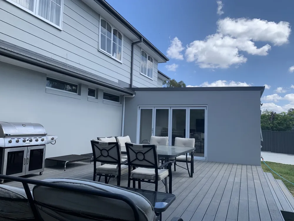 Freshly painted two-storey home exterior with a grey outdoor entertaining deck
