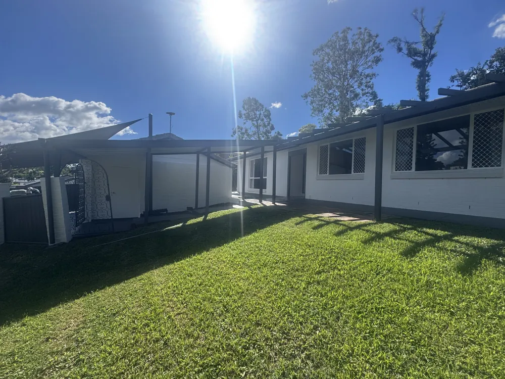 Freshly painted single-storey home exterior with dark trim over a green lawn