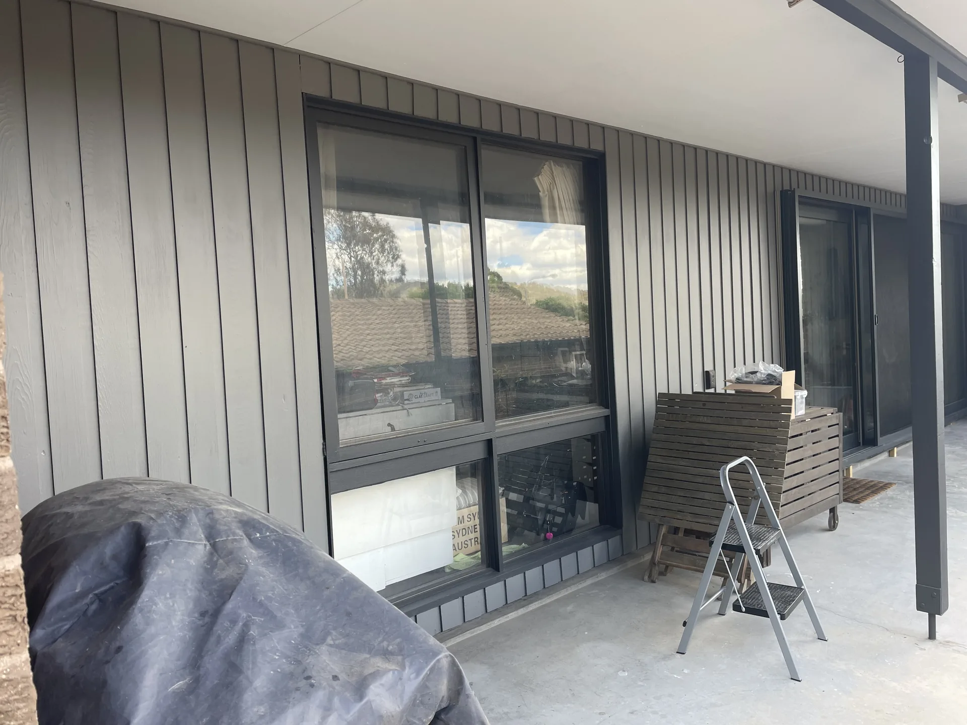 Exterior painting work in progress on a covered residential verandah