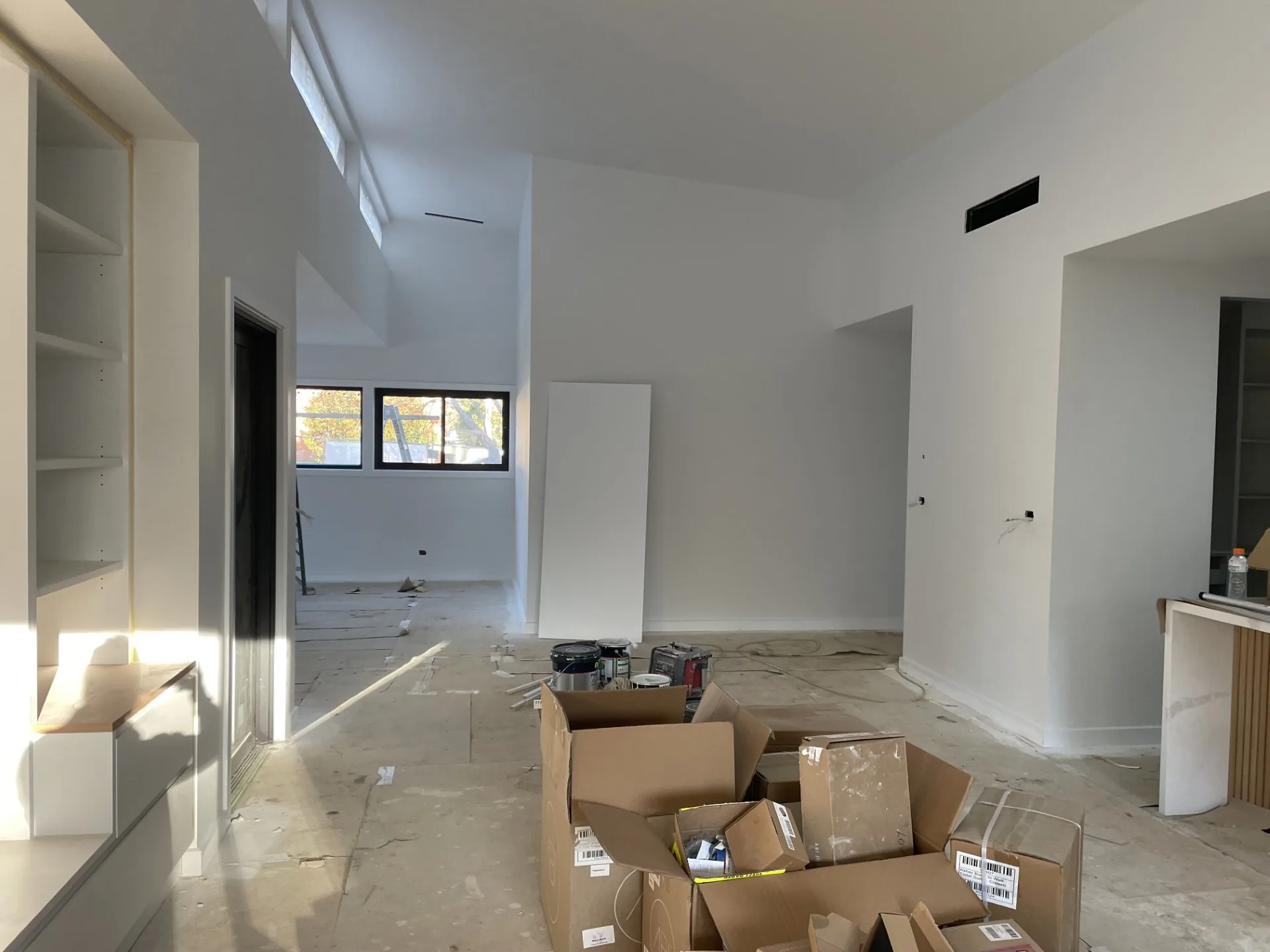 Freshly painted modern interior with white walls and work materials on the floor