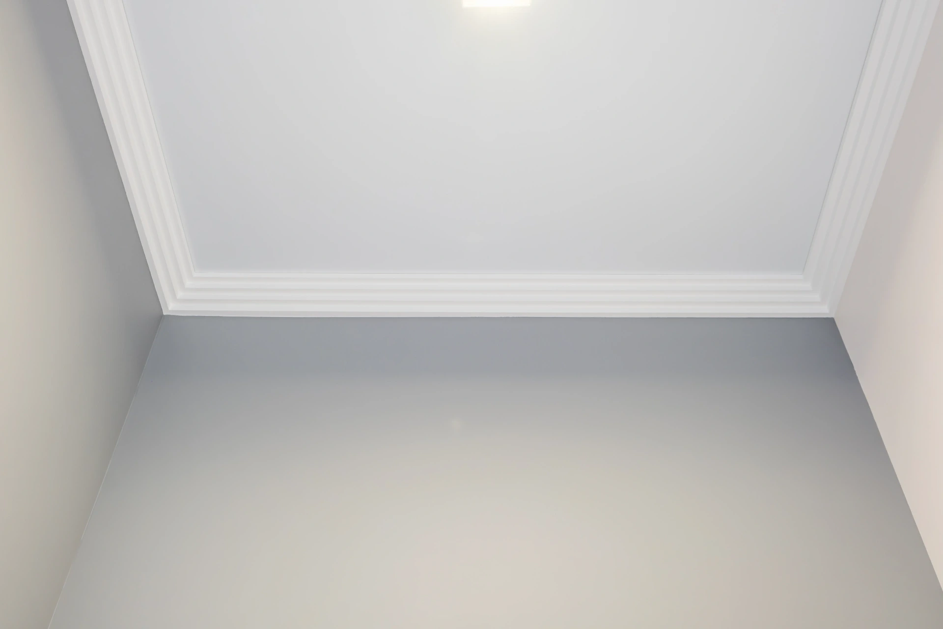 Freshly painted pale mint interior walls meeting a white ceiling and cornice