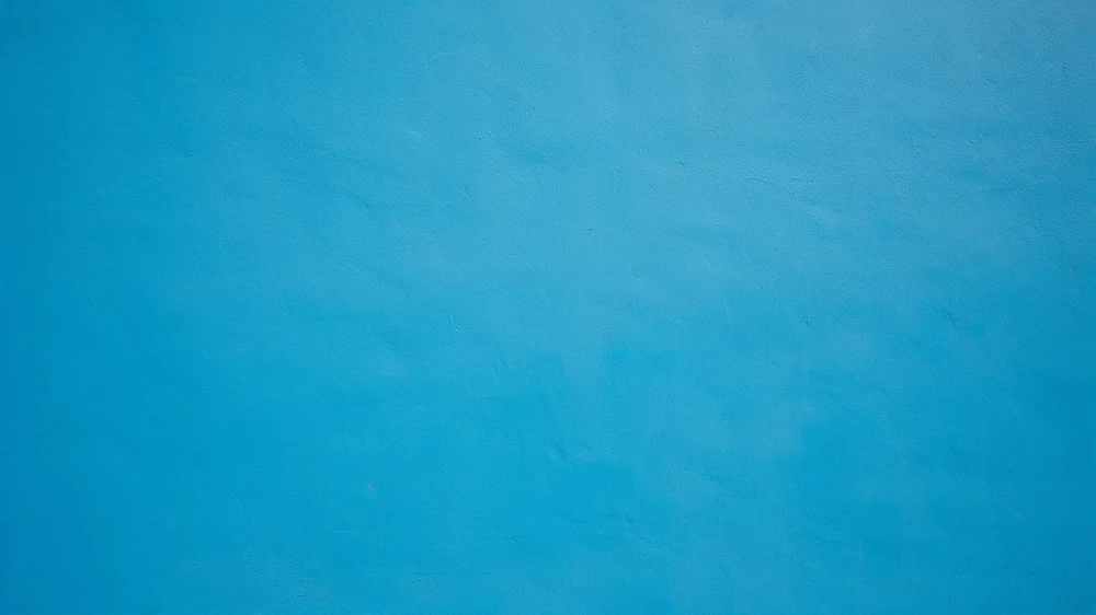 Close-up of a freshly painted bright blue wall with subtle surface texture