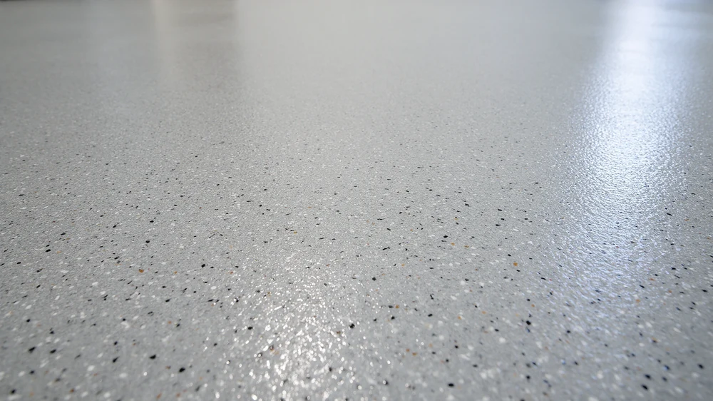Close-up of a speckled grey epoxy floor with a glossy finish