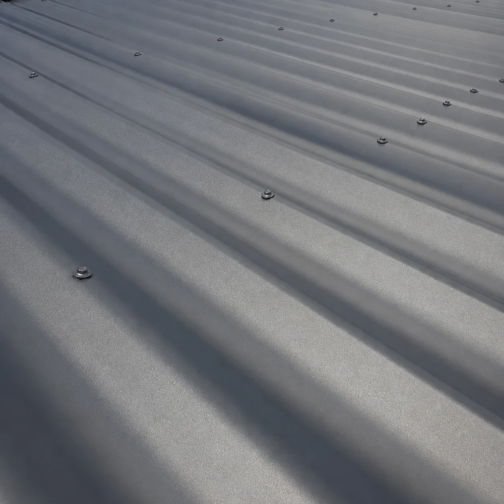 Close-up of grey Colorbond roofing with shallow ribs and visible fixings