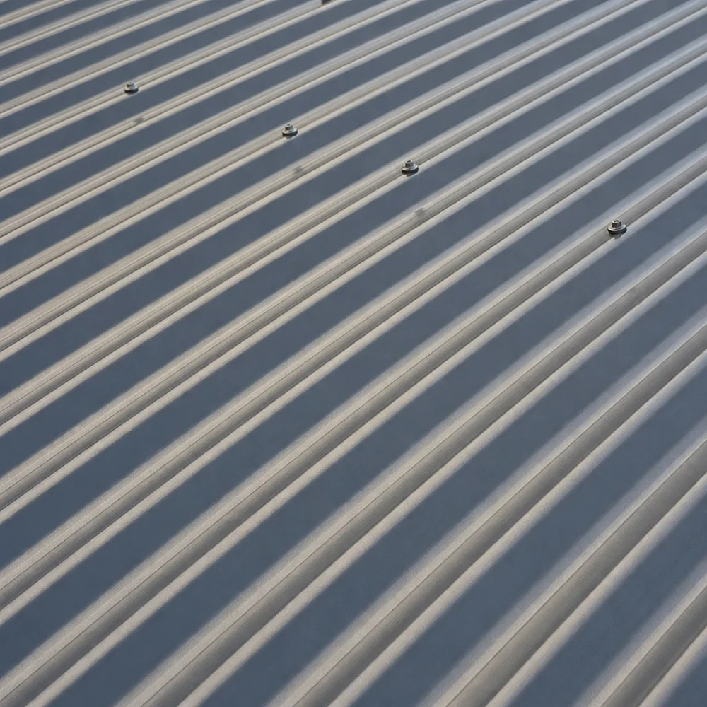 Close-up of silver-grey Colorbond roofing with repeating light and shadow lines