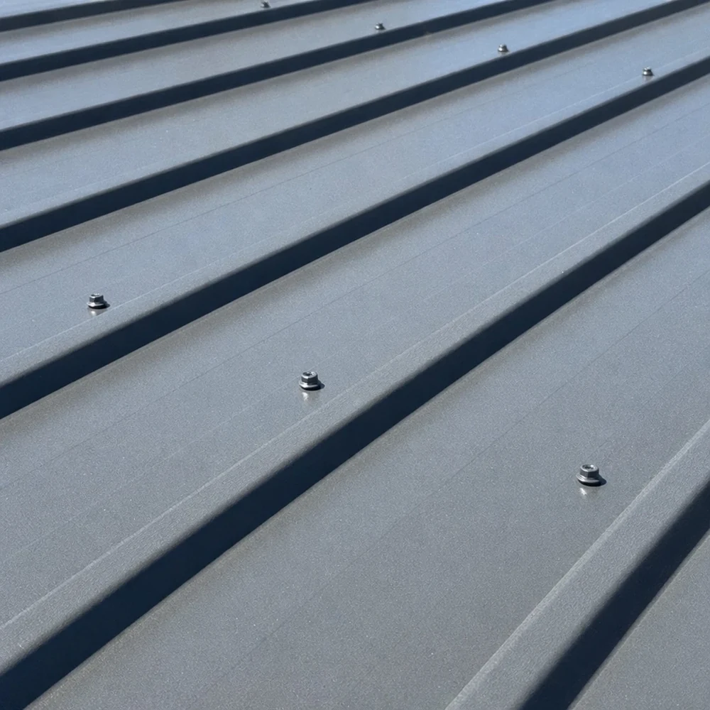 Close-up of grey Colorbond roofing with raised seams and small fixings