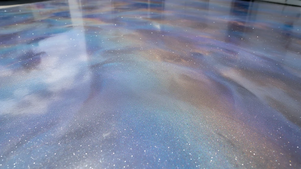 Close-up of a decorative blue and bronze metallic epoxy floor finish