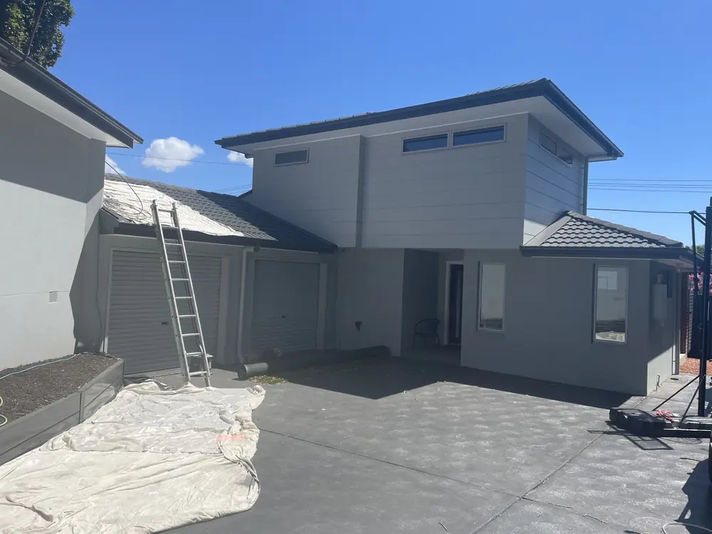 Home exterior during restoration work with access equipment beside the roofline