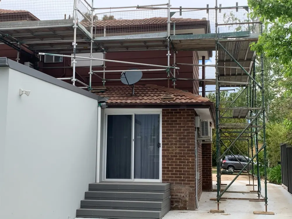 Two-storey home with scaffolding installed for high-level exterior preparation