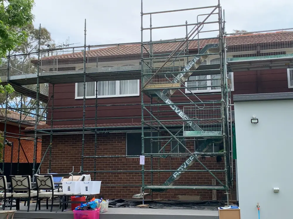 Scaffolding installed along a tiled roofline during exterior restoration work