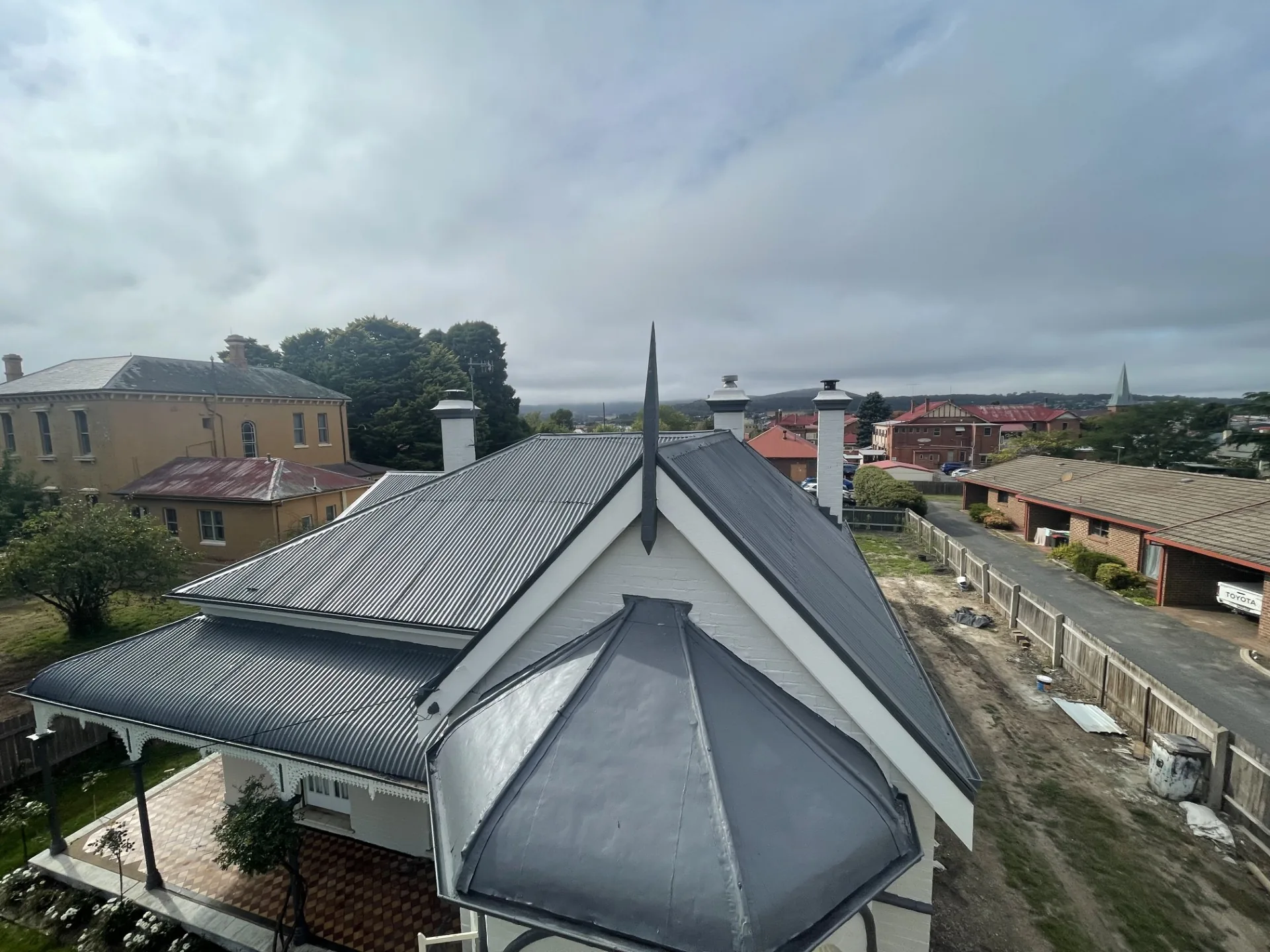Restored dark metal roof on a heritage-style home viewed from above